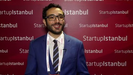 Amine Riahi being interviewed in front of a Startup Istanbul backdrop