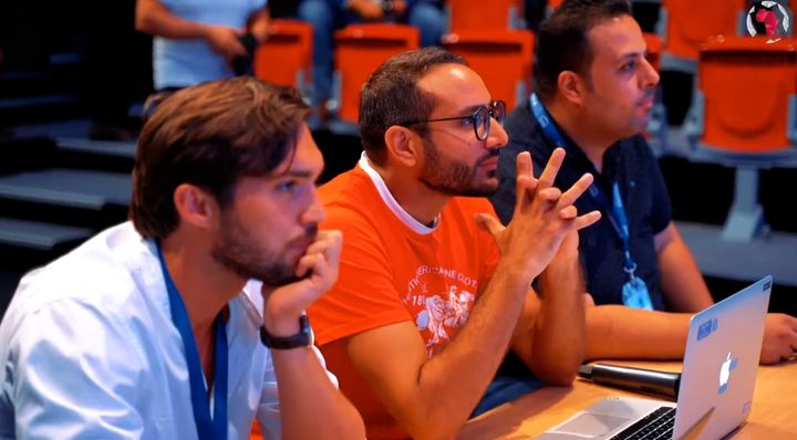 Amine Riahi, in an orange T-shirt, watching a pitch from the AfricArena judges’ table