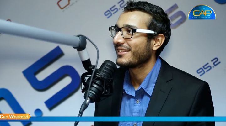 Amine Riahi smiling in the Cap FM radio studio during the Cap Weekend show
